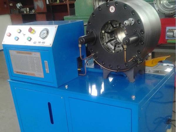 A blue digital automation high pressure hose crimping machine is on the ground.