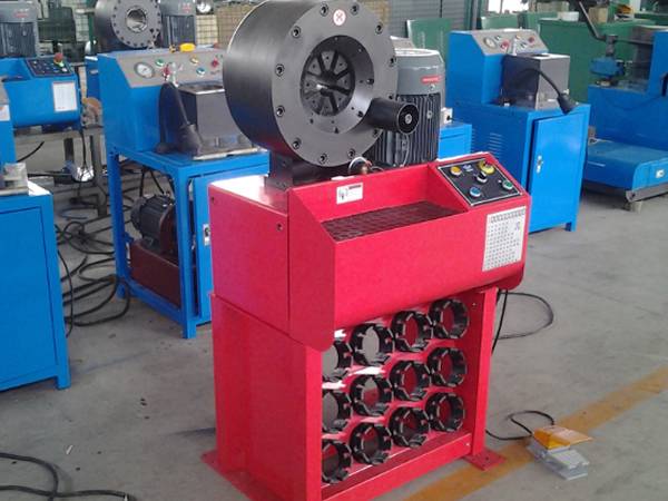 A red and several blue high pressure hose (4SP) crimping machines controlled by buttons are on the ground.