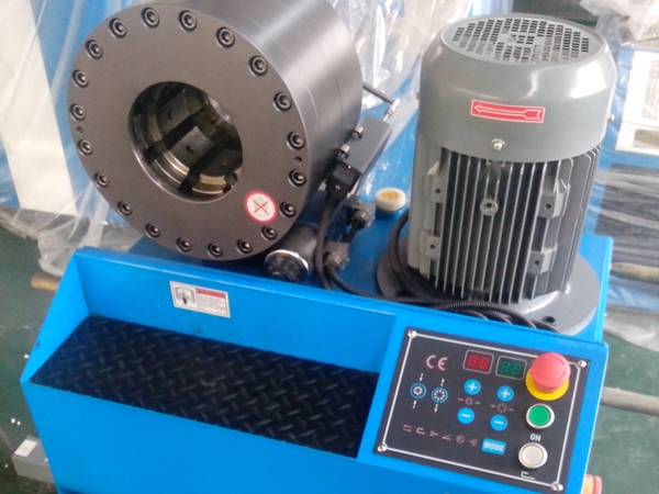 A blue high pressure hose crimping machine (type H) control by microcomputer is on the ground.